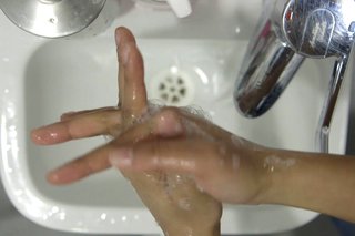 image of cleaning between the fingers over the sink