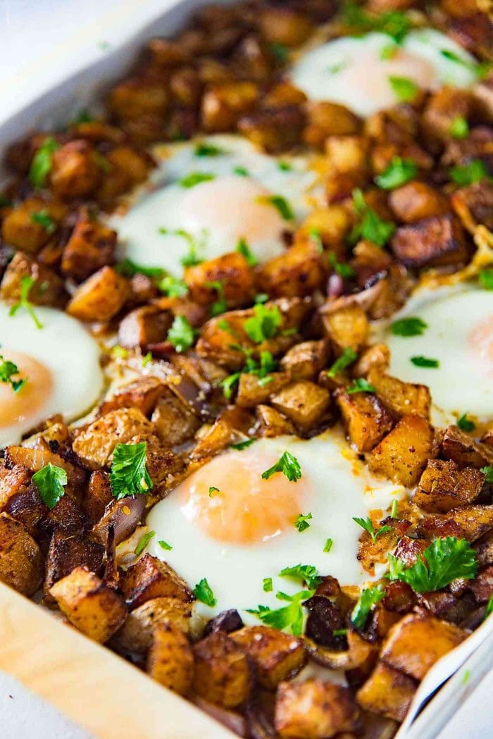 Sheet pan Breakfast Potatoes with Bacon and Eggs - This oven roasted breakfast potatoes and eggs with crispy bacon bits, is all cooked in the same sheet pan so you can enjoy your weekend mornings without standing over the stove. 